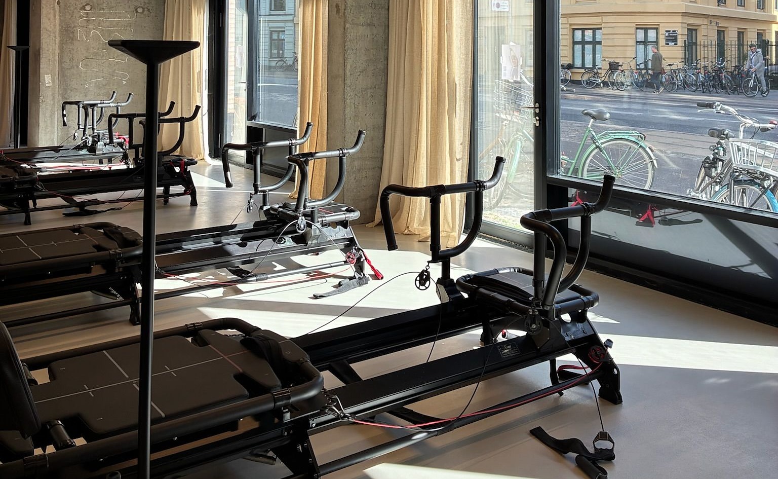 Megaformer row inside Some Good Moves with straps, rails, black carriage and daylight from the studio windows.
