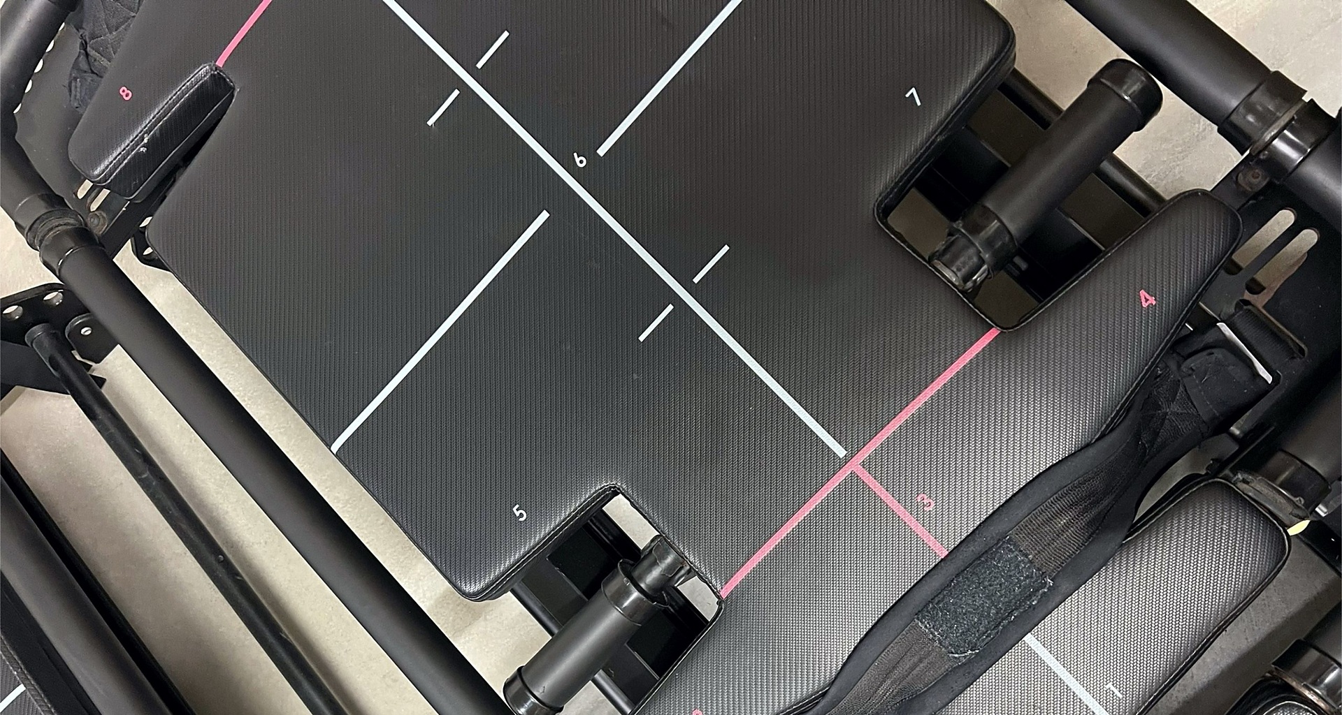 Top-down view of the black Megaformer carriage, numbered platform markings, rails and straps.