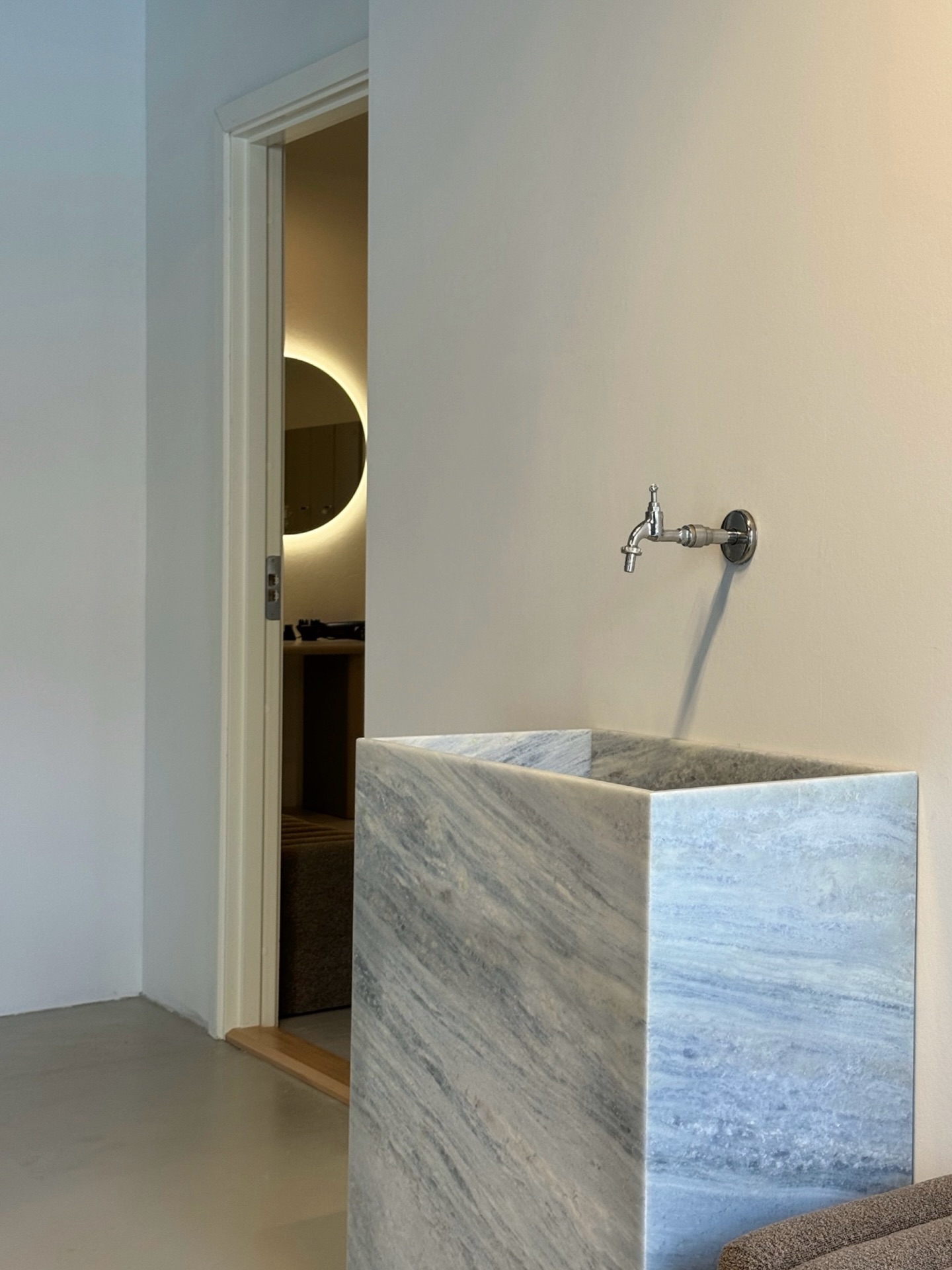 Marble faucet and sink detail at Some Good Moves with a changing room visible behind it.