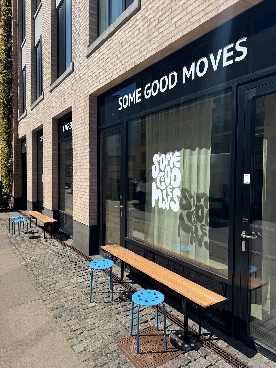 Some Good Moves storefront on Enghavevej with the studio sign, window logo and benches outside.