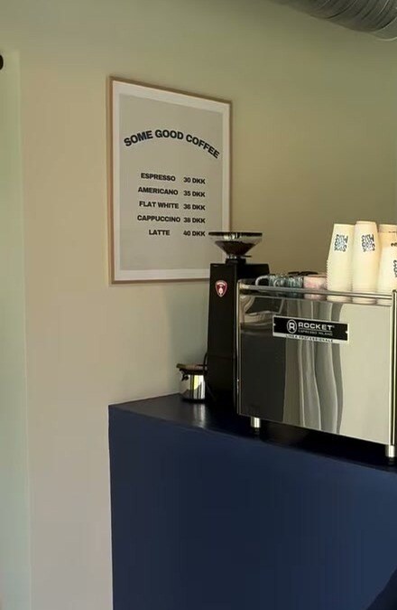 The blue coffee bar with the Some Good Coffee menu and espresso machine