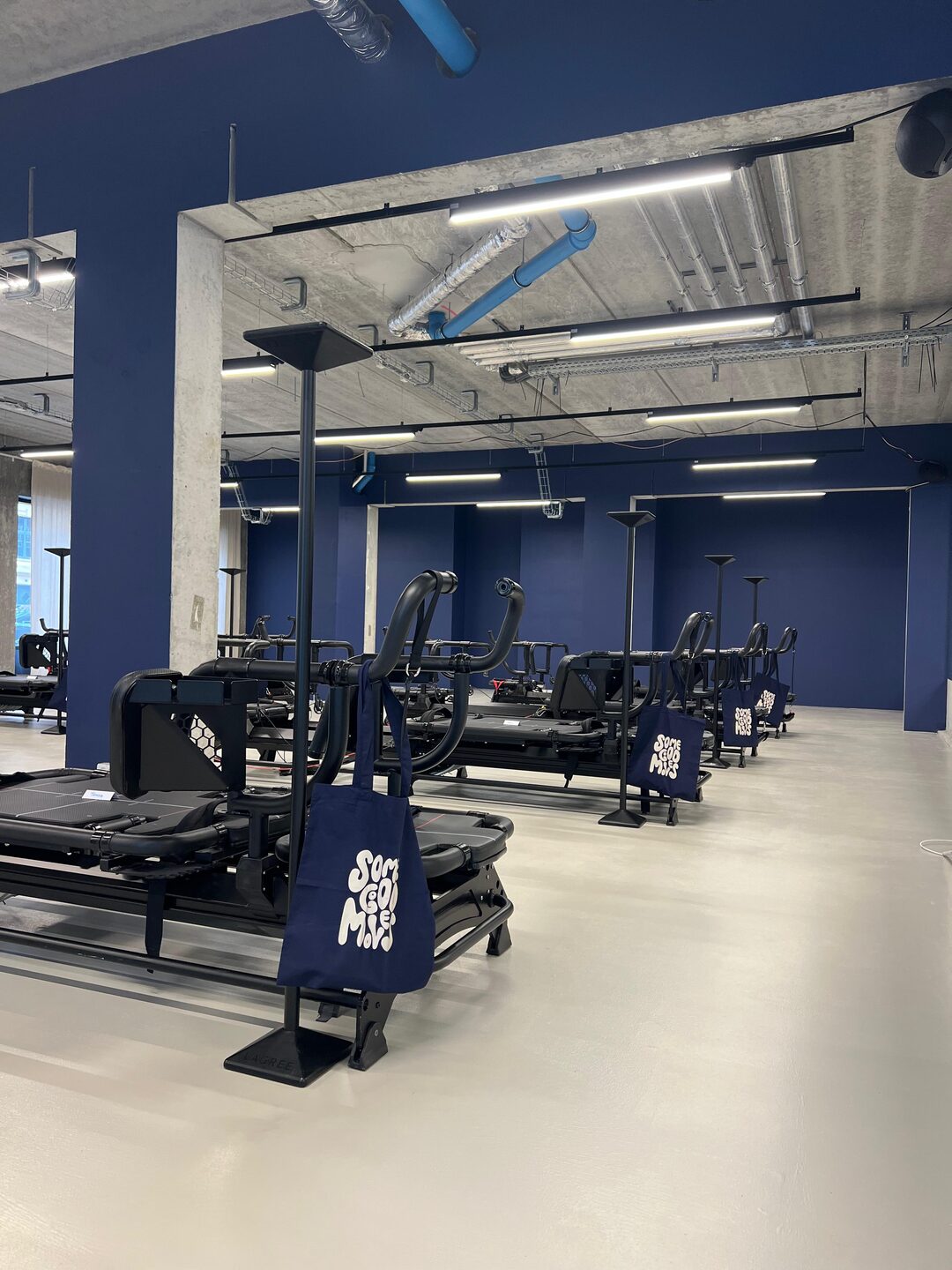 The Megaformer training room with its deep blue wall and branded machines